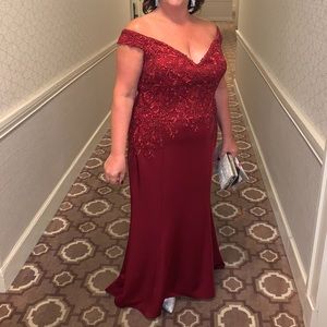 Madeline Gardner Woman’s wine colored off the shoulder evening gown.